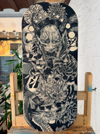 Obra original de Teixi Art sobre balance board: ilustración detallada en negro de inspiración oriental con máscara tradicional japonesa y elementos de la naturaleza sobre base de madera premium