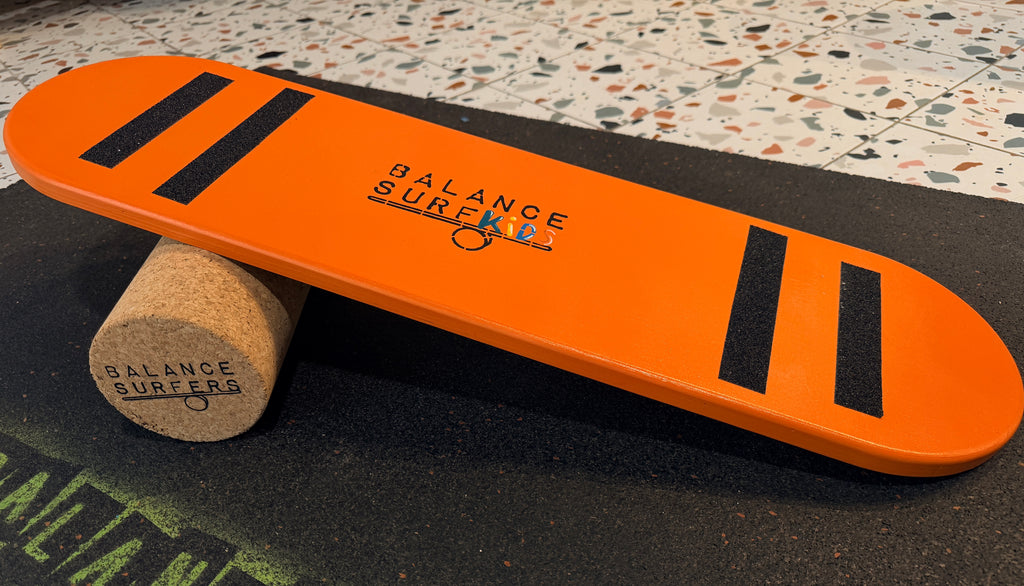 Tabla de equilibrio infantil Balance SurfKids color naranja brillante con bandas antideslizantes negras y logo central, fabricada artesanalmente en madera de abedul. Handmade balance board
