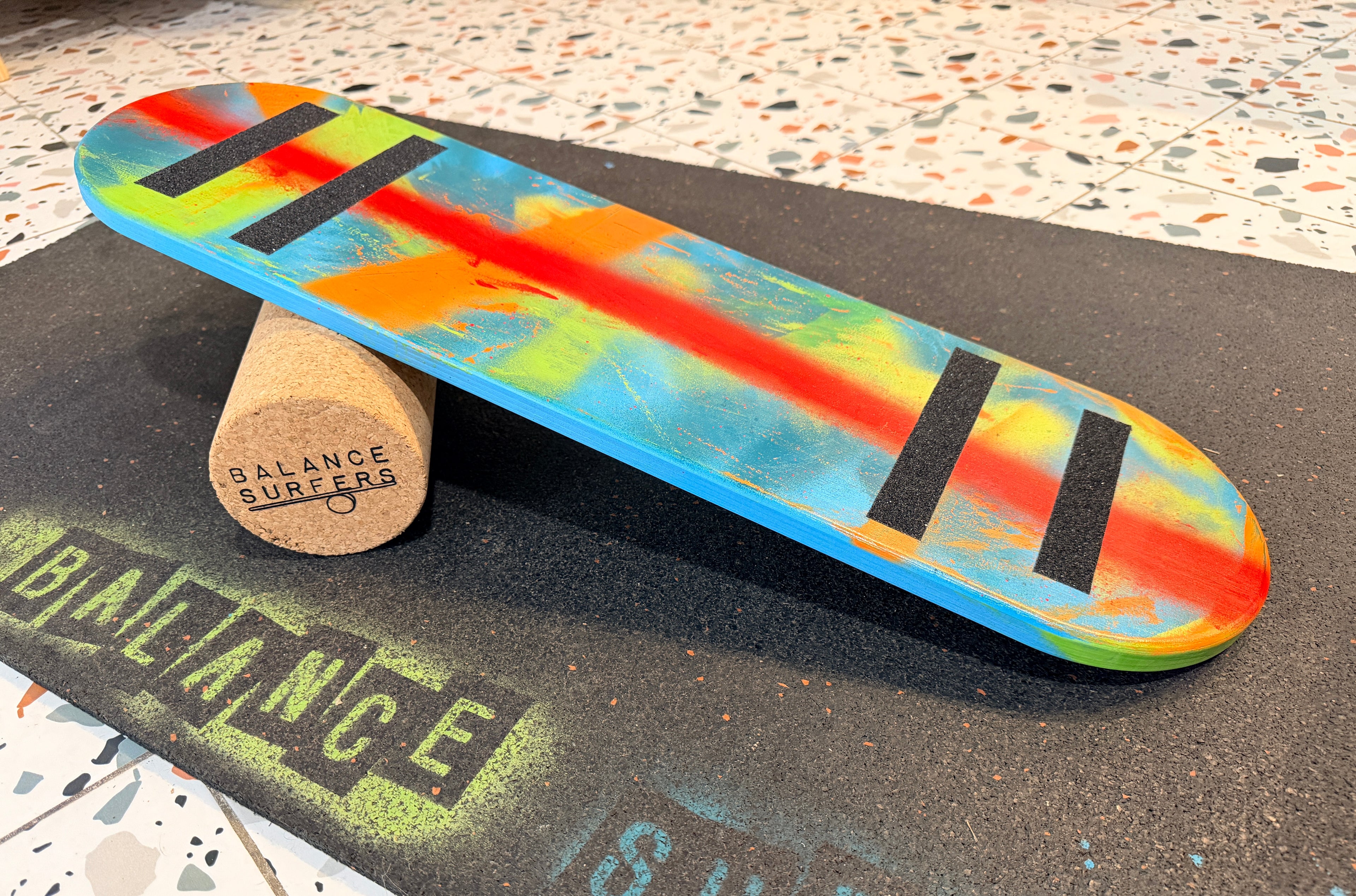 Tabla de equilibrio para niños edición Street Art con diseño multicolor pintado a mano, medidas adaptadas de 68x18 cm y topes de seguridad para un aprendizaje seguro.