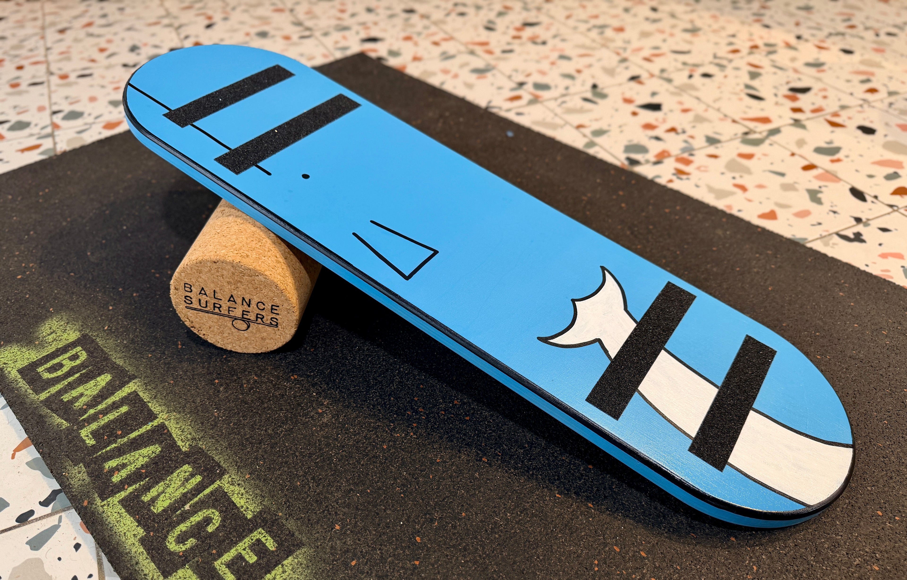 Tabla de equilibrio para niños con medidas adaptadas de 68x18cm con dibujo de ballena sobre rodillo de corcho natural de 9cm de diámetro