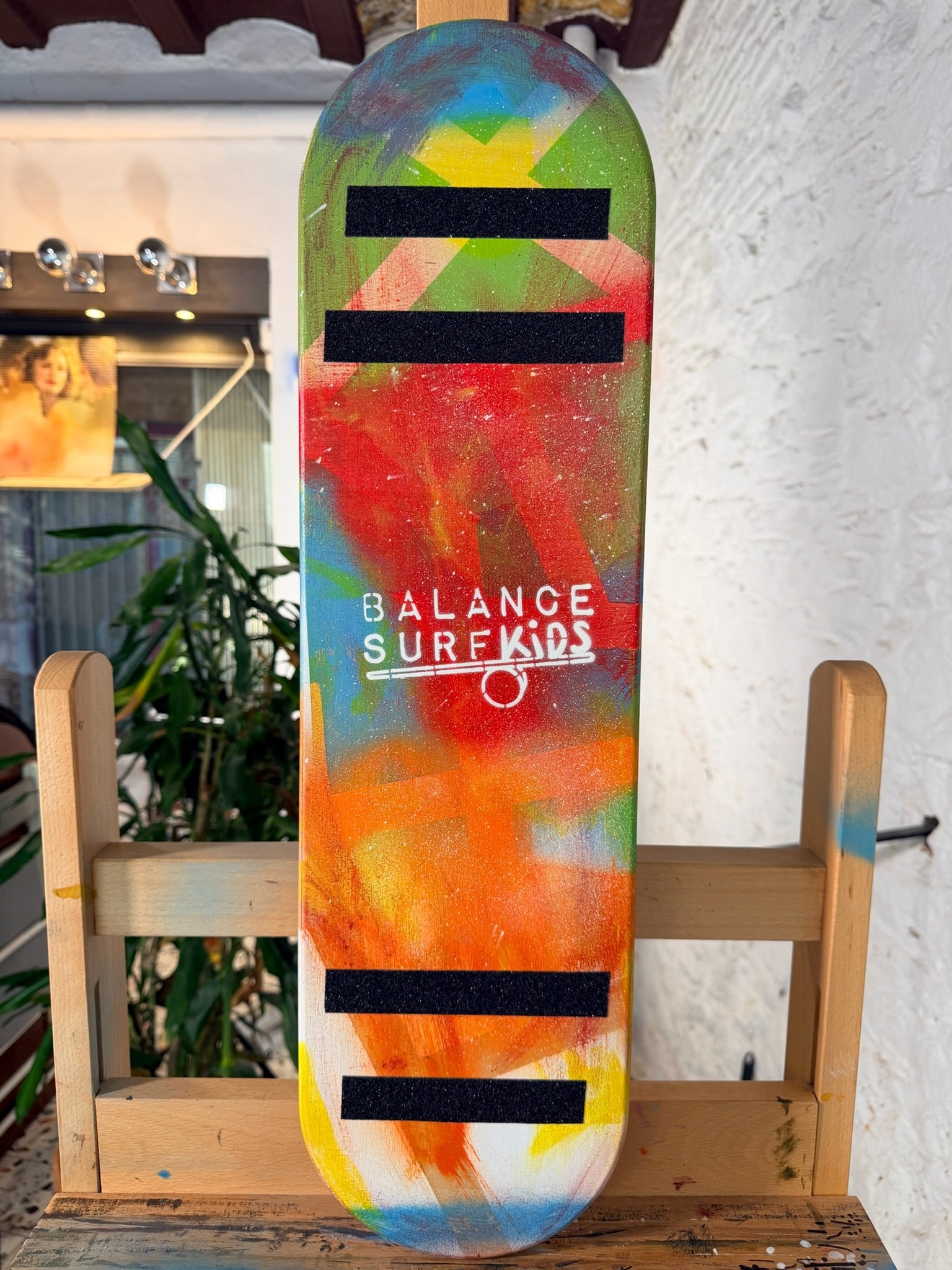 Tabla de equilibrio para niños edición Street Art con diseño multicolor pintado a mano, medidas adaptadas de 68x18 cm y topes de seguridad para un aprendizaje seguro.